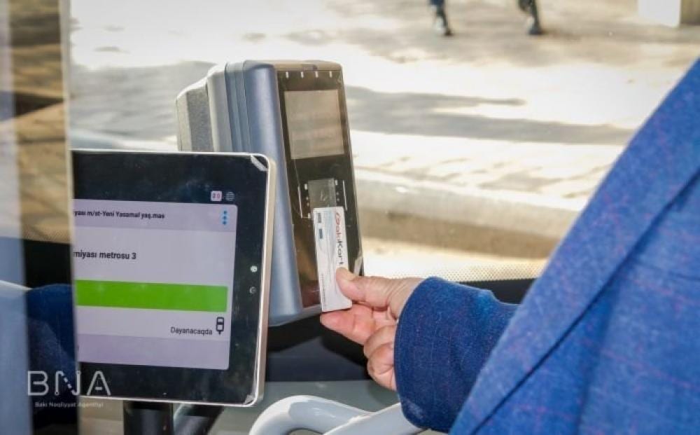 Sərnişin avtobusda validatora kart tutur